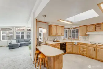 Kitchen features tile flooring, skylight & tile backsplash