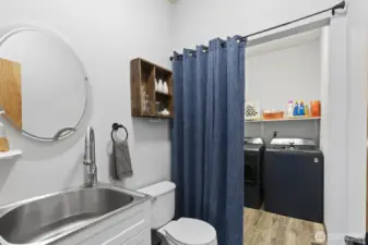 a charming 1/2 half bath with laundry- accessible from house and near interior garage door for muddy days