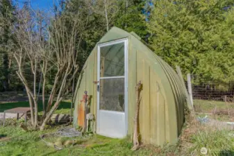 A small greenhouse inside one of the orchard/garden spaces