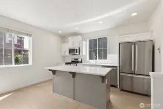 Featuring sleek stainless steel appliances and a spacious open-concept layout, this kitchen blends modern function with clean, contemporary style—perfect for everyday living and entertaining.