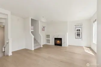 Bright and inviting, this additional view of the living room showcases the open layout, cozy gas fireplace, and natural light—creating a comfortable space to relax or entertain.