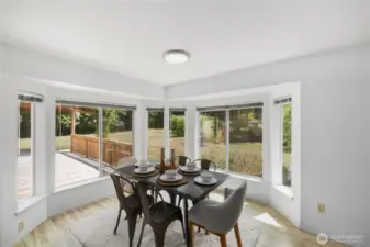The dining area is designed with bay windows that overlook the backyard and deck, bringing in abundant sunlight.