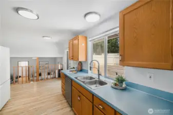 The kitchen overlooks the large deck and wisteria arbor. Just past the counter, an exterior door from the kitchen opens to the large deck.