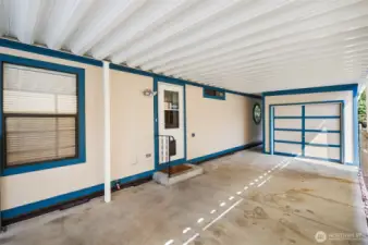 Coming out of the utility room into the covered patio, oversized outbuilding & walkway to the large backyard