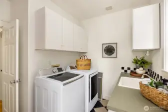 The laundry/utility room with storage, counter space and a mop sink.