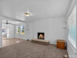 Main level living room with fireplace, new carpeting, fresh paint.
