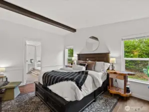 Spacious primary bedroom with vaulted ceilings, 5piece bath right in distance.