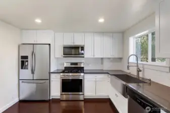 This functional kitchen is a chef’s delight, designed with an efficient layout that prioritizes both culinary flow and social connection. The workspace transitions effortlessly into a charming breakfast nook, creating a dedicated pocket of comfort for morning coffee or casual weeknight meals.