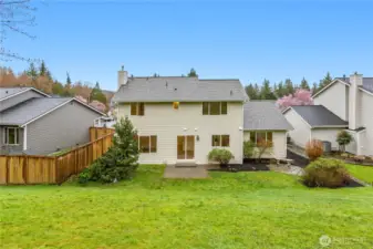 A view of the back of the home, yard and patio