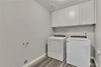 Laundry room with extra storage above.