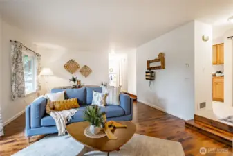 Large living area with engineered hardwood floors, fresh paint, new window treatments and cozy firepalce