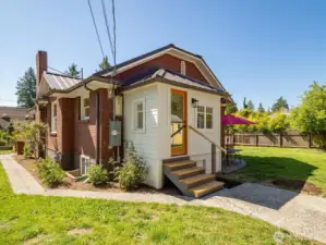 Sweet enclosed back porch!  The off-street parking is next to the fence on the east side here.