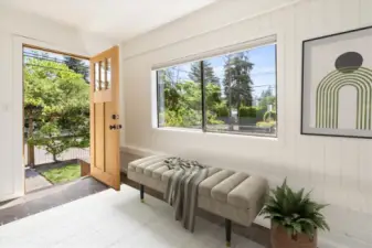 Enter into the enclosed, sunny front porch.
