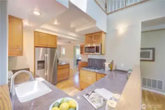 Modern kitchen with gas cooktop, slab counters, a window to the back yard and perfectly situated between the Family Room and Dining Room.