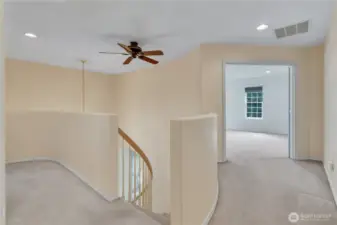 Upstairs landing looking down the hall toward the primary suite