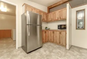 Corner of the kitchen with extra cabinets, microwave and access to the utility room and back door.