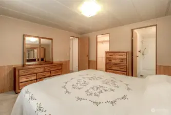 This view of the primary bedroom shows the bathroom, closet and the door to the living room.