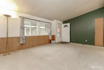 This view is of the front door and the window faces the covered wheelchair ramp and garage. This view is from the living room with the coat closet to the right.