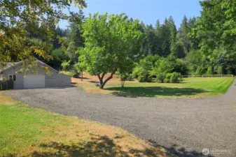 View of 2 car detached garage, pump room for individual well on right side of garage and view of bonus septic area with full utilities in back ground.