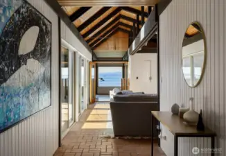 View from front door that leads to the family room with large flat screen TV, new wet bar, and three sliding doors that open to central home open courtyard with hot tub, BBQ, and room for additional entertaining opportunities.
