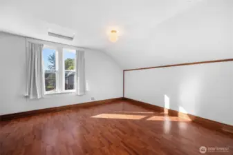 Primary bedroom with windows overlooking the street.