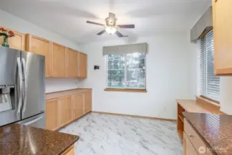 Another view of this kitchen looking from the open air breakfast bar into the kitchen eat in area with custom built-in cabinets for extra storage and full functionality.