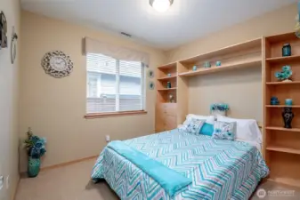 The second bedroom is full of options since this custom built in murphy bed system folds away for more space.