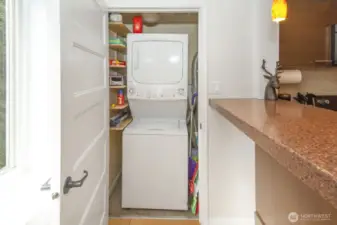 In-unit washer and dryer inside closet next to kitchen.