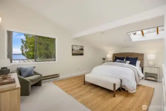 Generously sized loft with a water view,  vaulted ceiling and skylight