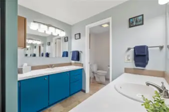 Primary bathroom has two sinks ample space, private toilet and tub.