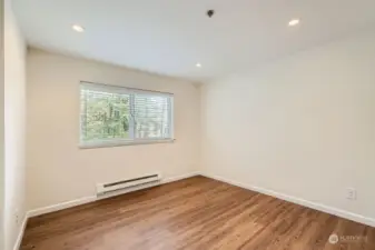 View of the master bedroom before the virtual staging. Fresh paint on walls and ceilings, new molding and Stainmaster PetProtect vinyl plank flooring. Recessed lighting. Both bedrooms face the peaceful green belt.