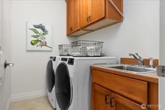 Conveniently located upstairs laundry room with deep sink and storage cabinets