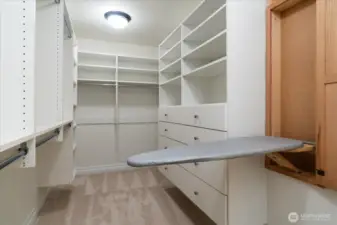 Generously-sized walk-in closet in primary suite with built-ins, and convenient ironing board