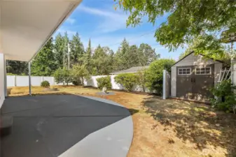 Half concrete rear deck is partially covered with sensor light  7 ft x 7 ft Rubbermaid (1V64-1 Roughneck) storage shed with double doors  Firepit  Apple and pear trees
