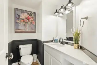 Updated powder bath with quartz vanity and new lighting.