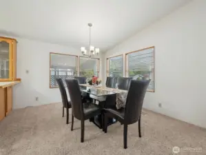 View of the dining room, love the cathedral ceilings, breakfast bar to your left and all the windows. Dining set is for sale :)