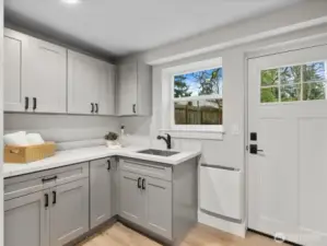 Large laundry room with cabinets, sink, and heat