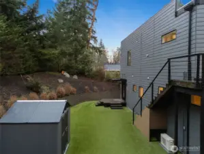 Fenced for pets and play, this backyard also includes a convenient storage shed.