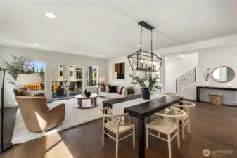 Dining & Living Area: Expansive wood flooring, designer lighting, and walls of glass create a warm and inviting main living space. The layout easily accommodates large gatherings or quiet evenings, with access to the covered outdoor deck just steps away.  These photos are of the actual, staged home being sold at Foxmoore. However, all photos, renderings, site maps, and floorplans are for visualization purposes only. Plans, colors, building orientation, finishes, home outlook, and other details can and WILL vary.