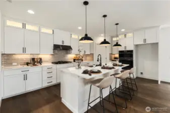 Kitchen: The chef’s kitchen showcases a large quartz island with bar seating, pendant lighting, and abundant counter space. Custom cabinetry, a designer backsplash, and premium stainless appliances create the ideal blend of form and function, perfect for both everyday living and entertaining.  These photos are of the actual, staged home being sold at Foxmoore. However, all photos, renderings, site maps, and floorplans are for visualization purposes only. Plans, colors, building orientation, finishes, home outlook, and other details can and WILL vary.