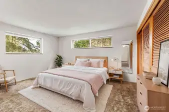 View of the staged main floor primary suite with plenty of closet space and a private bathroom.