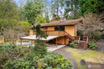 Enjoy the peaceful setting with a circular drive and carport, large storage shed, front deck, and a gorgeous backyard patio with firepit, all surrounded by mature landscaping and towering trees that provide exceptional privacy.