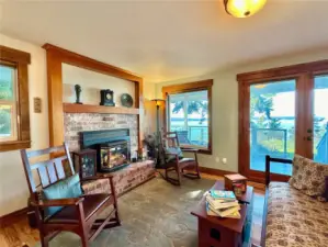 Sitting room with fireplace is open to the dining area and kitchen with access to the wraparound deck.