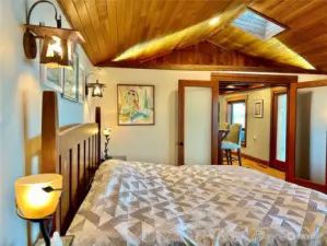 Spacious primary bedroom with vaulted ceilings.