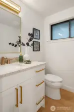 Powder room serves main level with custom vanity, hardware and skimmed walls