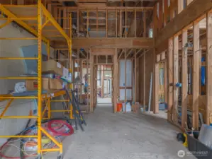 Master bedroom with walk in closets on either side and upper washer dryer hookup. Master bath in distance. Above is attic storage.