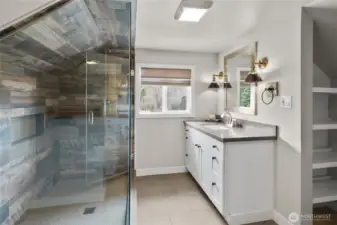 Take in lavish primary bathroom w/ tile floors, custom shower, quartz counter and linen closet.