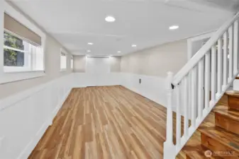 Once you arrive at the bottom of the stairs is one of the 2 lower floor bedrooms. Perfect for a couple of sets  bunk beds to accommodate more sleeping space. The charming wainscot gives this area such a classy vibe. This area was one the lower level garage if you want to convert back to storage space.