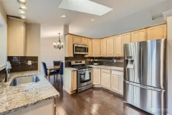TASTEFUL KITCHEN WITH QUALITY CABINETS, GRANITE COUNTERS, & EASE OF ACCESS TO DINING RM.