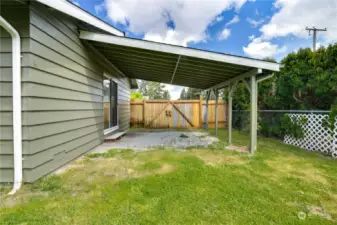 The attached carport is set behind the wooden gate for added privacy and protection.